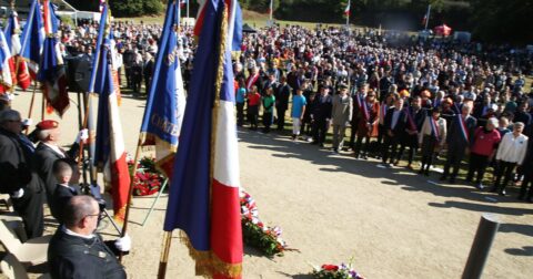cérémonie d'hommages avec civils et militaires en tenue portant des drapeaux