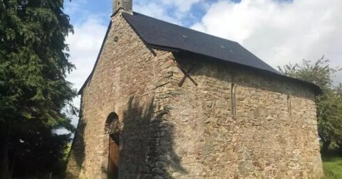 petite chapelle en pierre et ardoise à côté d'arbres