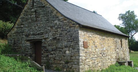petite chapelle en pierre et ardoise dans un pré
