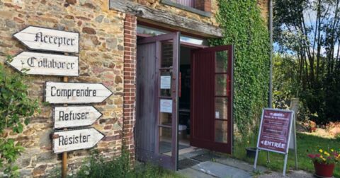 Entrée du Musée de la Résistance avec panneaux directionnels en bois
