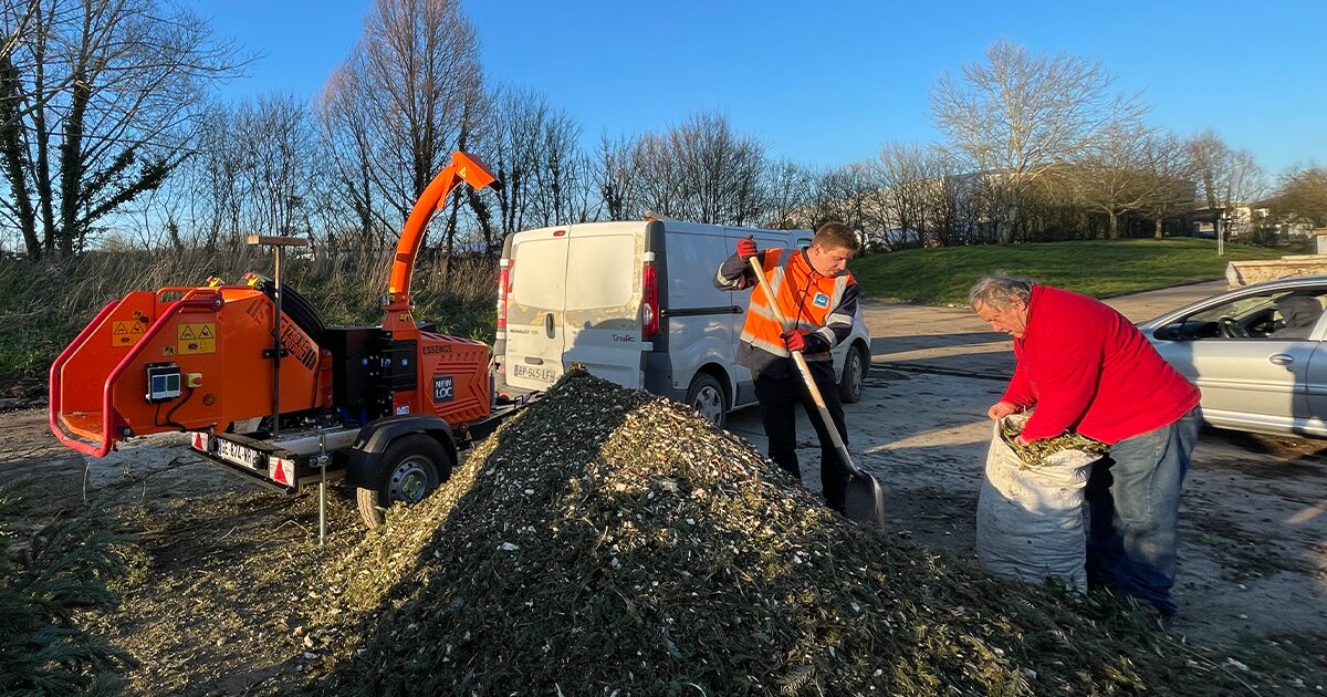 machine à broyer des végétaux dans une déchetterie avec usager qui récupère le broyat