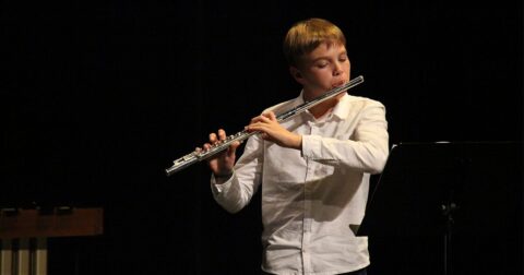 jeune musicien avec sa flûte traversière sur scène