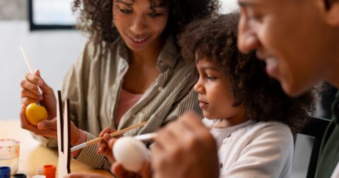 parents et leur fille faisant une activité créative sur une table