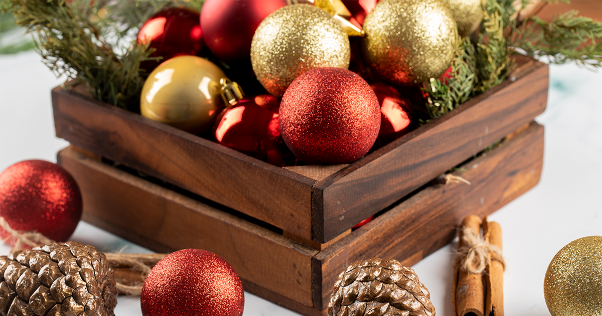 boules de Noël rouges et dorées dans une caisse en bois