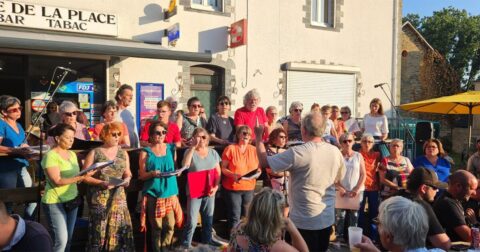 chorale d'adultes chantant sur place de village pour la fête de la musique