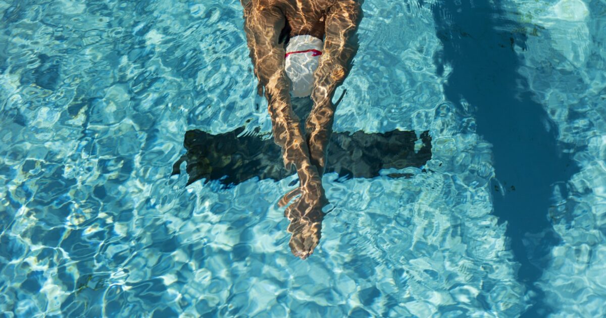 homme nageant dans une ligne d'eau d'un bassin sportif