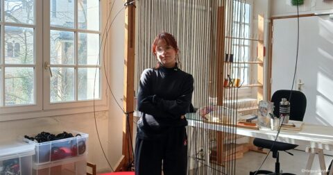 Femme artiste debout devant son atelier de broderie