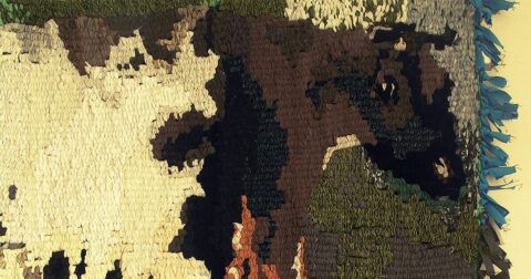 Broderie verte et jaune représentant une vache