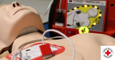 mannequin allongé au sol avec défibrillateur