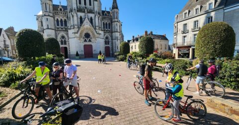familles en vélo sur une place devant une grande église