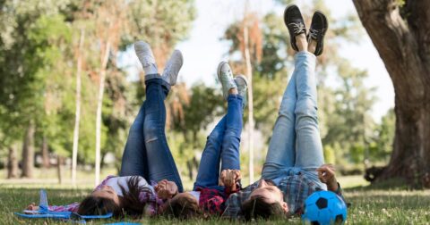 famille allongée sur le dos l'herbe les jambes en l'air