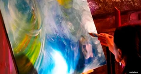 artiste peignant sa toile multicolore