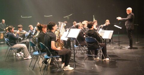 Orchestre en répétition sur scène avec chef d'orchestre en face
