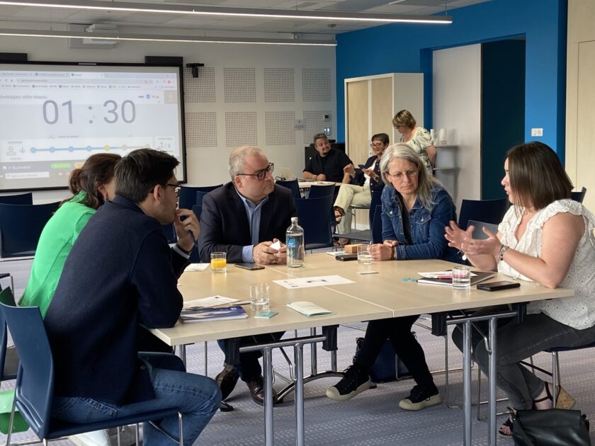 Groupe d'hommes et de femmes autour d'une table lors d'un atelier de travail