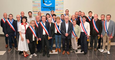 Élus hommes et femmes debout avec echarpe tricolore posant devant le logo de la Communauté de Communes Châteaubriant-Derval