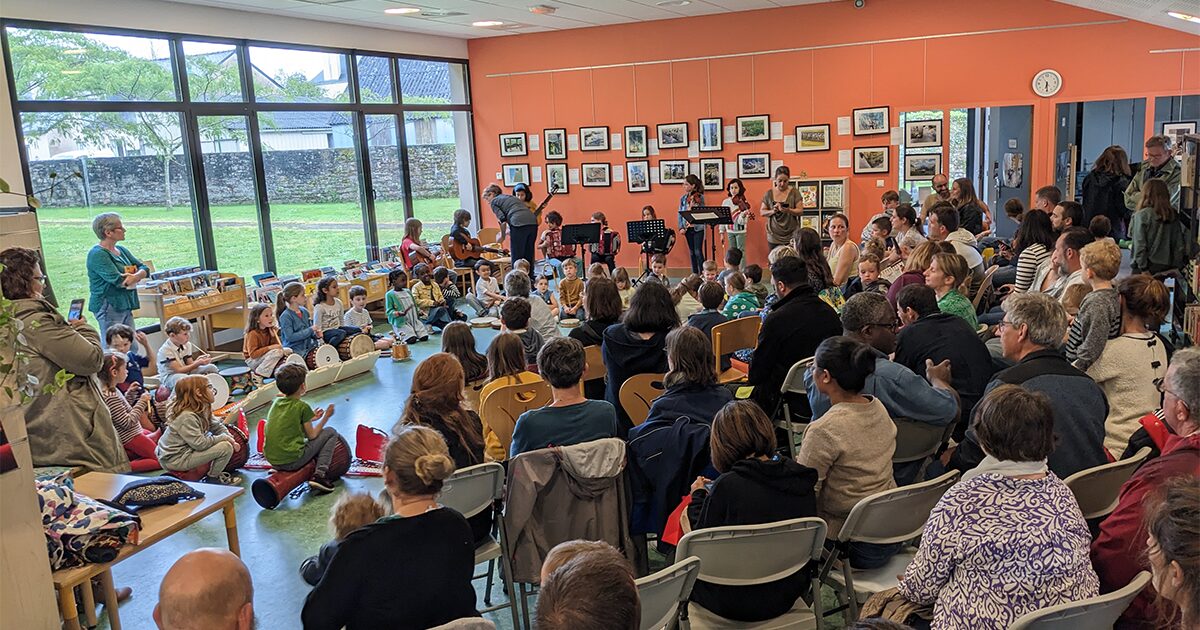 Jeunes musiciens avec tams-tams jouant devant leurs parents dans une médiathèque