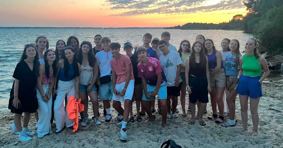 groupe de jeunes posant sur la plage à la nuit tombée