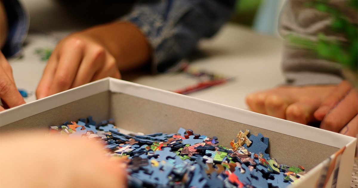 gros plan sur les mains d'enfants réalisant un puzzle